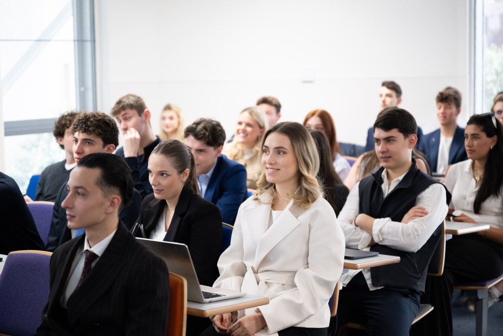 Des élèves sont assis dans une salle de classe et sont attentifs à un cours qui leur est dispensé.